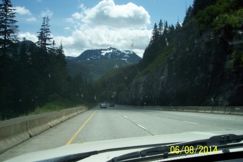 1990 Ford Bronco - A scenic drive through a mountain pass on a sunny day with a few cars on the road.