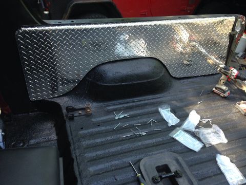 1979 Ford Bronco - Installing diamond plate in a truck bed, with tools and hardware laid out.