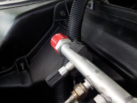 1976 Ford Ranchero - This image shows a close-up of vehicle air conditioning lines, including a red cap and a black knob.