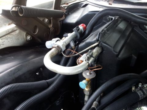 1976 Ford Ranchero - Close-up view of air conditioning system components within a vehicle's engine compartment.