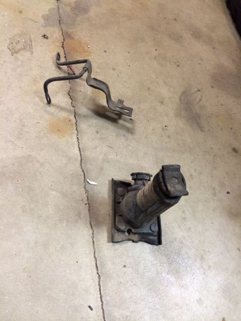 1995 Ford Bronco - A car jack and a metal bracket are shown lying on a concrete surface.
