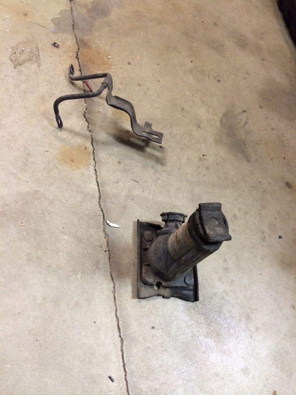 car jack and metal bracket on concrete floor