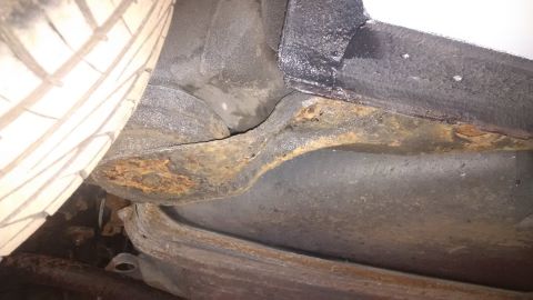 1994 Ford Thunderbird - The underside of a vehicle shows significant rust damage on the frame and surrounding components.