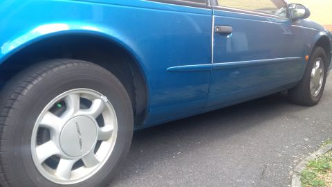 1994 Ford Thunderbird - Side view of a blue 1994 Ford Thunderbird coupe, showing its body style and wheel design.