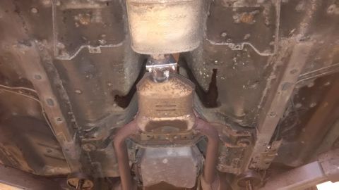1994 Ford Thunderbird - Underside view of a vehicle's exhaust system, including the catalytic converter and muffler.