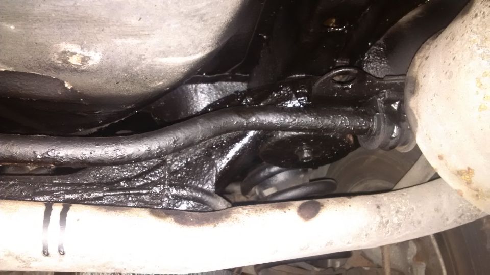 Underbody of a vehicle with black rustproofing applied to suspension components and frame rails