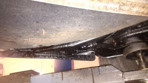 1994 Ford Thunderbird - Undercarriage view of a vehicle, focusing on the frame and suspension components that have been treated with undercoating.