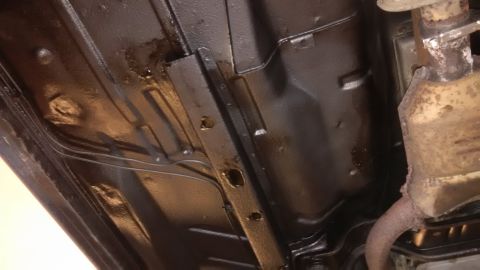 1994 Ford Thunderbird - Underside view of a vehicle undergoing rust repair and undercoating, with the Supermotors.net logo visible in the corner.
