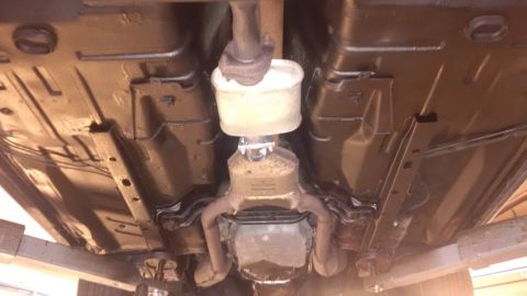 1994 Ford Thunderbird - The underbody of a car, showing the exhaust system and catalytic converter, has been treated.