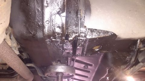 1994 Ford Thunderbird - Close-up view of a vehicle's undercarriage, highlighting areas of undercoating and potential rust.