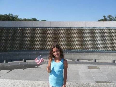 1971 Ford Ranchero - Girl holding an American flag at a memorial site with a wall of stars.