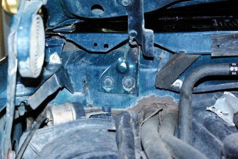 1995 Ford Bronco - Detail shot of engine bay components, including hoses and mounting hardware, with visible signs of wear and corrosion.
