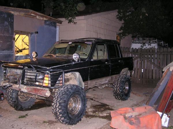 Black Jeep Comanche pickup truck with off-road tires and brush guard