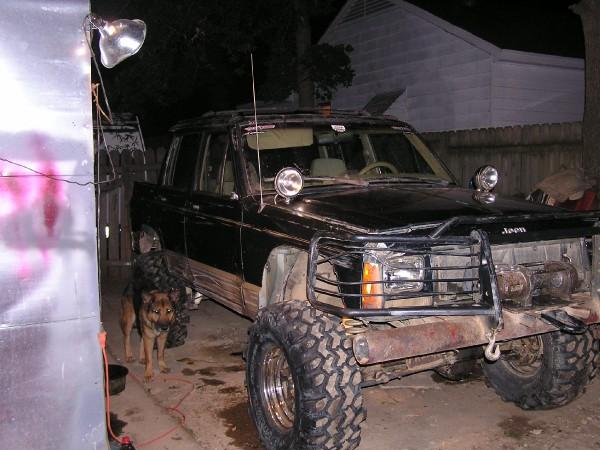 Black Jeep Comanche pickup truck with large tires and a brush guard