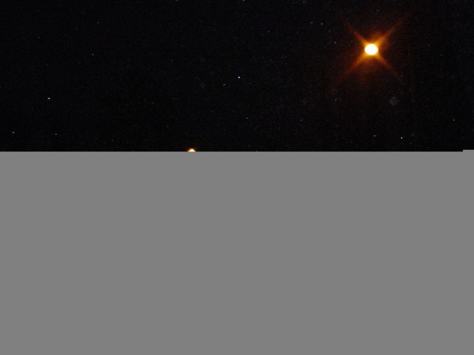 Night sky with stars and a bright, glowing celestial body, possibly a planet or star, with a faint orange glow