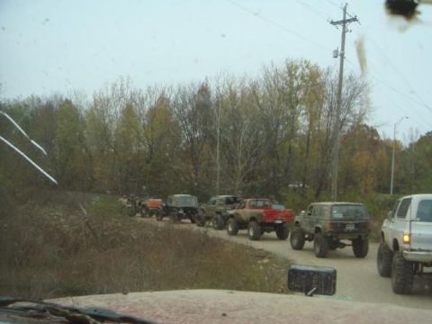 Line of lifted off-road vehicles driving on a dirt road