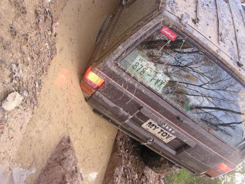 Jeep stuck in mud, rear view, with license plate MY TOY