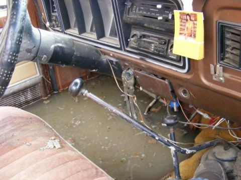1978 Ford Bronco interior with flooded floor, brown seats, and dashboard