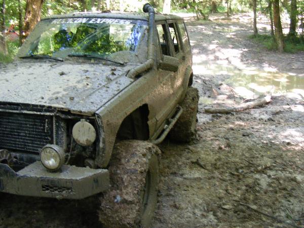 Mud-covered SUV with snorkel and "REELTON EXPRESS" on windshield, stuck in mud