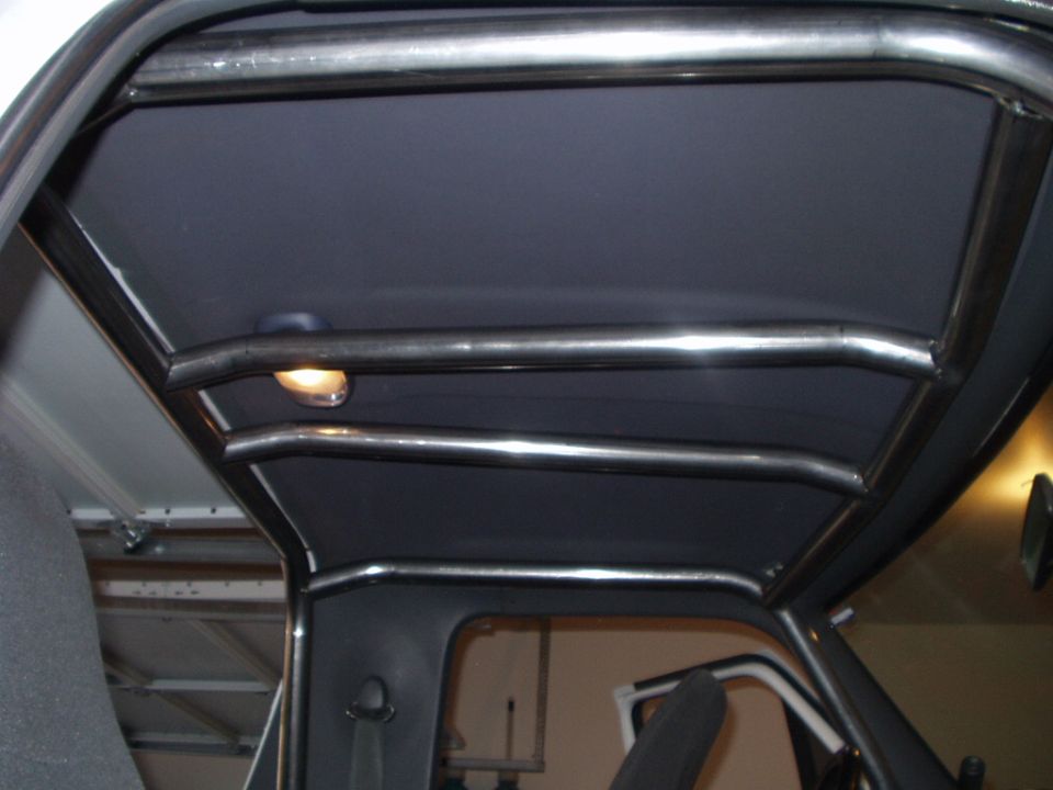 Chrome roll cage bars against dark headliner inside an SUV interior