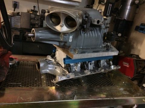 1996 Ford Bronco - A supercharger assembly, likely for a performance engine build, is shown on a workbench with various engine components.