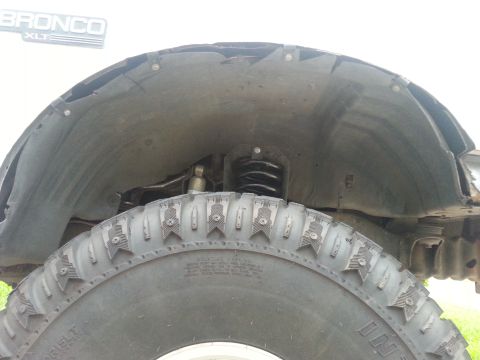 1992 Ford Bronco - Close-up of a tire and inner fender well, with a Bronco XLT badge visible.