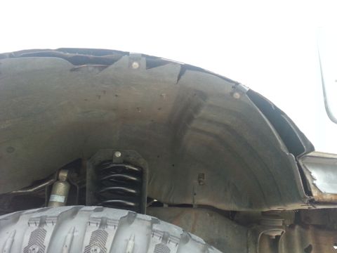 1992 Ford Bronco - Close-up view of a vehicle's inner fender well and suspension, revealing modifications and signs of wear.