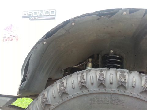 1992 Ford Bronco - Close-up of the inner fender well and tire of a Bronco XLT, showing modifications.