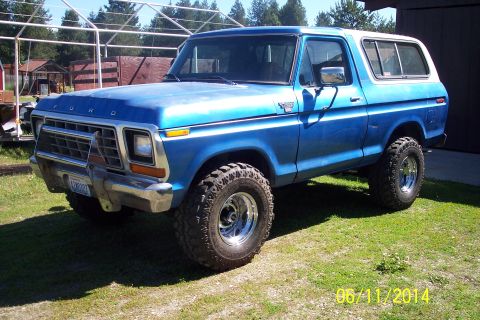 1978 Ford Bronco - This blue 1978 Ford Bronco features a white top and is shown from a three-quarter front angle.