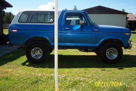 1978 Ford Bronco - Side view of a blue and white 1978 Ford Bronco with aftermarket wheels.