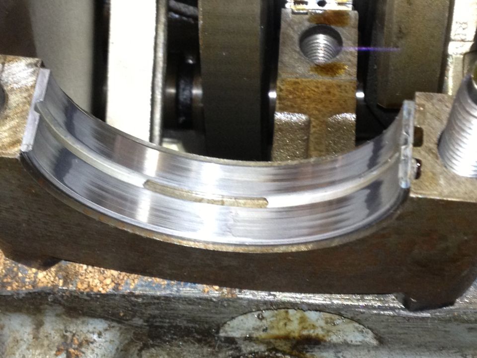 Close-up of a worn engine bearing with visible scoring