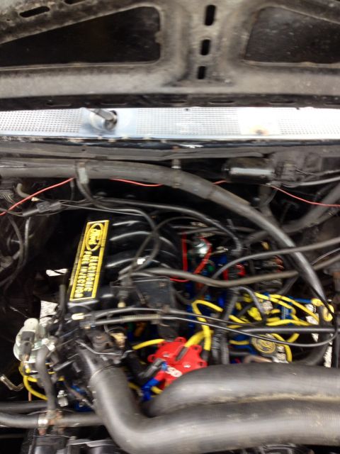1988 Ford Bronco - Engine bay detail showing the yellow Ford Electronic Fuel Injection cover, consistent with a 1988 Ford Bronco.