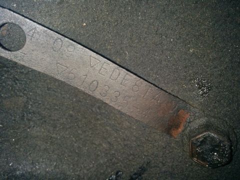 1988 Ford Bronco - Close-up of a metal identification tag with stamped alphanumeric characters.