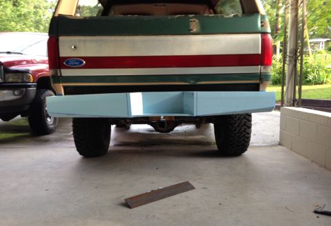 1989 Ford Bronco - Rear view of a Ford Bronco with a custom light blue bumper and a distinctive tri-color stripe on the tailgate.