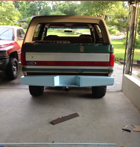 1989 Ford Bronco - The rear of a Ford Bronco, a custom light blue bumper and a multi-colored stripe design on the tailgate.