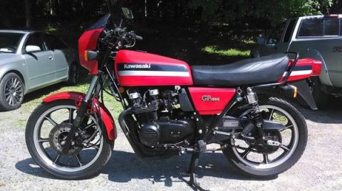 2008 Ford Crown Victoria - A red Kawasaki GP550 motorcycle is parked outdoors next to a silver sedan and a pickup truck.