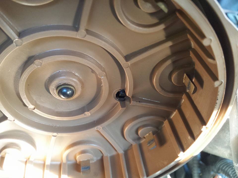 Interior of a brown plastic distributor cap with a metal ball bearing in the center