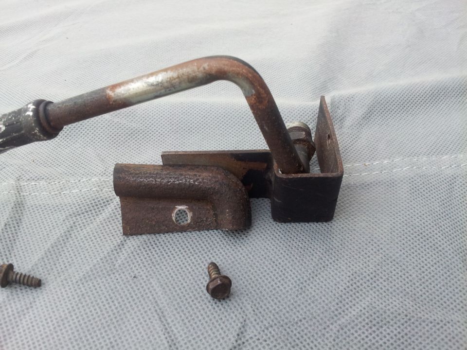 Rusted metal lever mechanism with screws on a textured surface