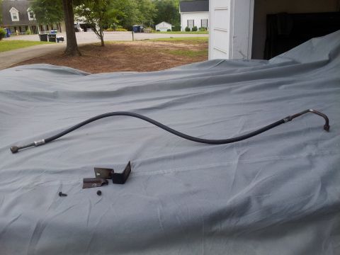 1976 Ford Ranchero - Air conditioning hose and bracket, likely removed from a vehicle for repair or replacement.