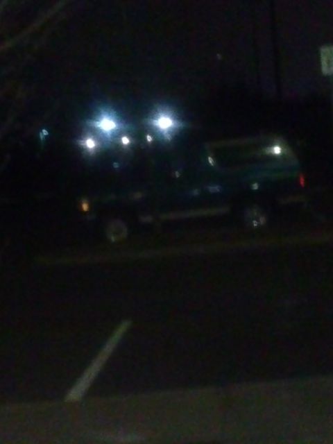 1996 Ford Bronco - SUV parked at night under bright lights.