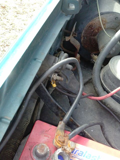1996 Ford Bronco - A view of a car's engine bay, focusing on the battery and associated wiring.