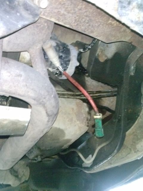 1996 Ford Bronco - Close-up view of an exhaust system component, likely an oxygen sensor.