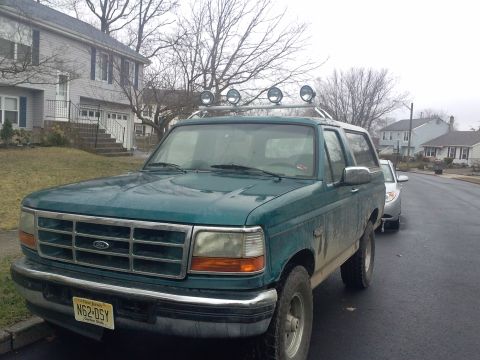 1996 Ford Bronco - 1996 Ford Bronco with a light bar parked on a street.