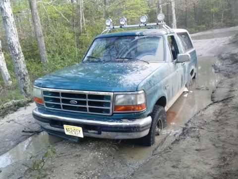 1996 Ford Bronco - This 1996 Ford Bronco is stuck in a muddy trail, with its front tires submerged.