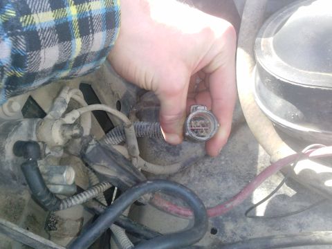 1996 Ford Bronco - Close-up of an electrical connector being held in a vehicle's engine bay.