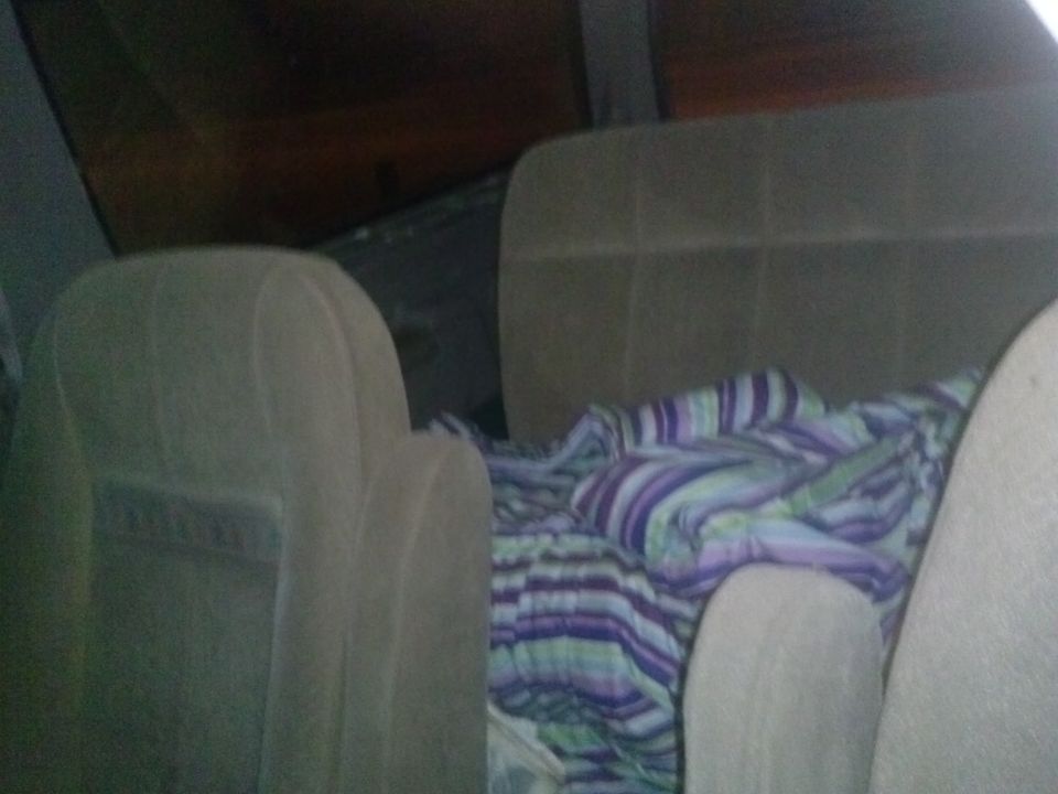 Interior view of vehicle seats with a striped blanket covering the back seat