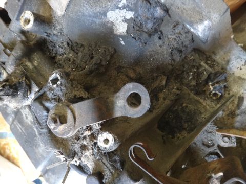 1993 Ford Taurus - A close-up view of a mechanical linkage on a heavily soiled engine part.