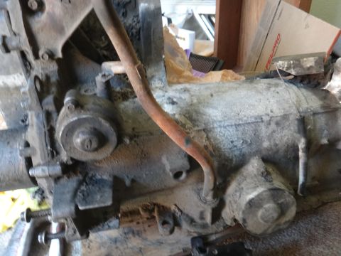 1993 Ford Taurus - A close-up view of a dirty engine block and transmission assembly, with a rusty pipe visible.