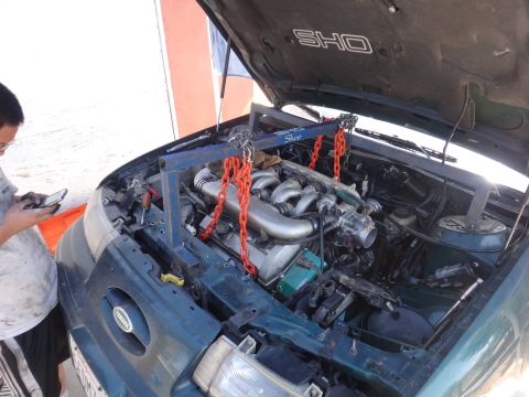 1993 Ford Taurus - Engine is being supported by a hoist as it is removed from a 1993 Ford Taurus SHO.