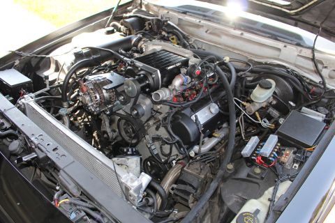 2003 Ford Crown Victoria - Overhead angled view of an engine bay with a Kenne Bell supercharger, alternator, brake reservoir and exposed fuse box.